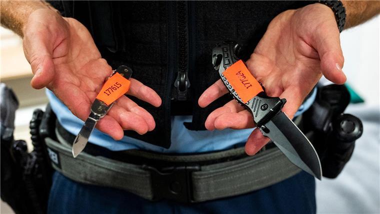 Ein Bundespolizist zeigt sichergestellte Messer.