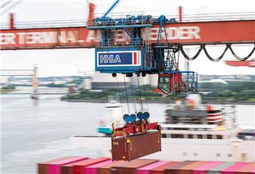 Ein Container wird auf dem Container-Terminal Altenwerder im Hamburger Hafen mit einer Containerbrücke auf ein Schiff geladen.