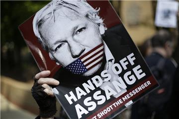 Ein Demonstrant hält ein Schild mit dem Porträt des Wikileaks-Gründers Assange in die Luft. 