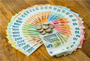 Euro-Münzen und Geldscheine liegen auf einem Tisch.