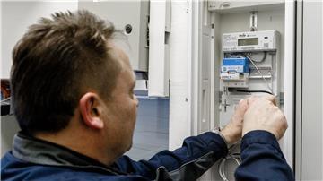 Ein Elektriker montiert einen digitalen Stromzähler mit einem Smart-Meter-Gateway zur Datenübertragung.