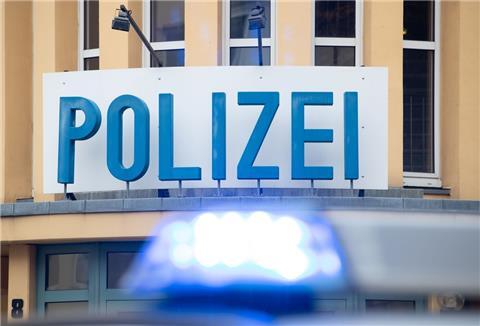 Ein Einsatzwagen der Polizei steht vor einer Dienststelle