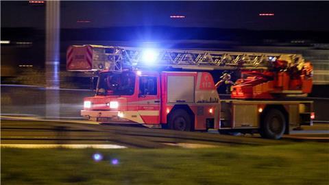 Ein Fahrzeug der Feuerwehr mit Drehleiter fährt mit Blaulicht.