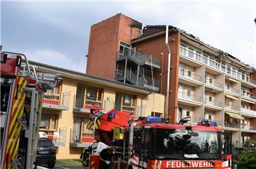 Ein Fahrzeug der Feuerwehr steht vor dem Pflege- und Altenheim. Das gesamte Dach ist abgebrannt. 96 Menschen mussten aus dem Gebäude gerettet werden. 