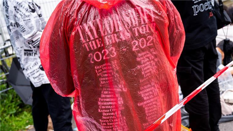 Ein Fan der Sängerin Taylor Swift wartet vor dem Konzert im Volksparkstadion mit Kleidung zum Schutz gegen Regen auf den Einlass.