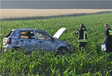 Ein Feuerwehrmann misst die Temperatur des Motors vom Unfallauto im Maisfeld.
