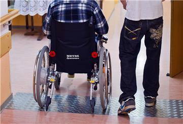 In einem Seniorenheim betreut ein Mann einen älteren Mann, der im Rollstuhl. Ein freiwilliges Jahr bringt mehr als Erfahrung: Auch für die Rente zahlt es sich aus – und das ganz ohne Antrag.