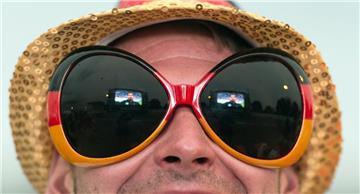 Ein Fußballfan mit überdimensionaler Sonnenbrille verfolgt  beim Public Viewing auf dem Messegelände in Freiburg die EM-Begegnung Deutschland gegen Polen. Foto Seeger/dpa