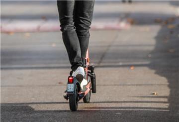 Ein junger Mann fährt mit einem E-Scooter