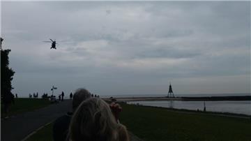 Ein Helikopter fliegt über ein Stück Strand nahe der Kugelbake in Cuhaven. Dort wurde eine Weltkriegesbombe gefunden. Derzeit wird sie untersucht.