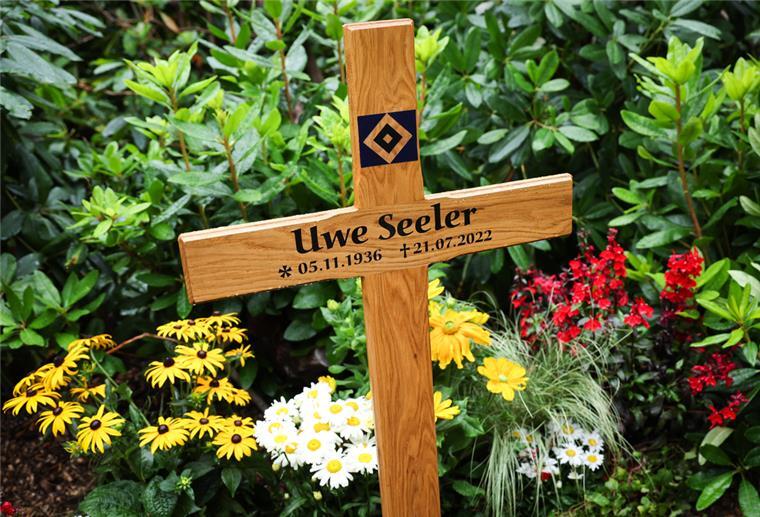 Ein Holzkreuz steht auf dem Grab der Fußballlegende Uwe Seeler.