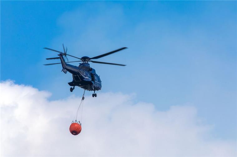 Ein Hubschrauber der Bundespolizei transportiert Löschwasser zu einem Brandherd in der Nähe der evakuierten Ortschaft Alt Jabel.
