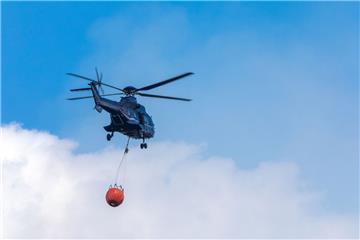 Ein Hubschrauber der Bundespolizei transportiert Löschwasser zu einem Brandherd in der Nähe der evakuierten Ortschaft Alt Jabel.
