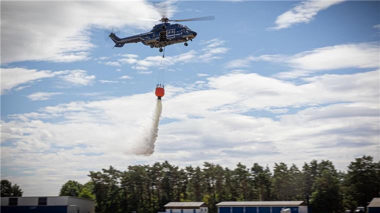 Lösch-Helis statt Flugzeuge – Land sieht sich bestätigt Ein Hubschrauber der Bundespolizei wirft bei einer Waldbrandübung Wasser aus einem Löschwasserbehälter ab.