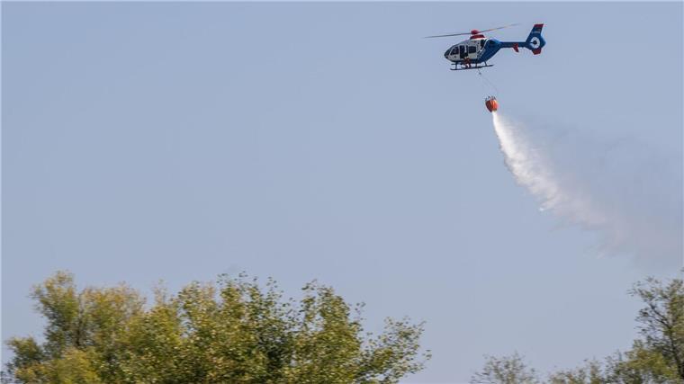 Feuerwehren üben Einsatz mit Hubschrauber Ein Hubschrauber der Polizei wirft bei einer Übung zur Waldbrandbekämpfung Löschwasser ab.