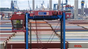 Ein Hubwagen fährt zwischen Containern im Hamburger Hafen umher. (Archivbild)  