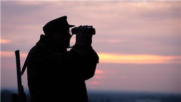 Ein Jäger blickt durch sein Fernglas in der Abenddämmerung. In Nordrhein-Westfalen startet die Messe Jagd & Hund.