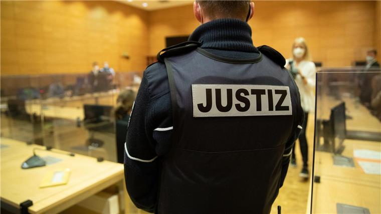 Ein Justizbeamter steht in einem Gerichtssaal.