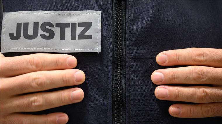 Ein Justizbeamter steht in einem Gerichtssaal.