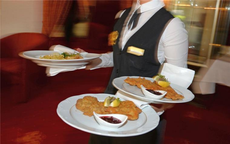 Ein Kellner serviert Schnitzel. Für eine solche Mahlzeit ist die Mehrwertsteuer höher als für Bratwurst auf dem Pappteller. 