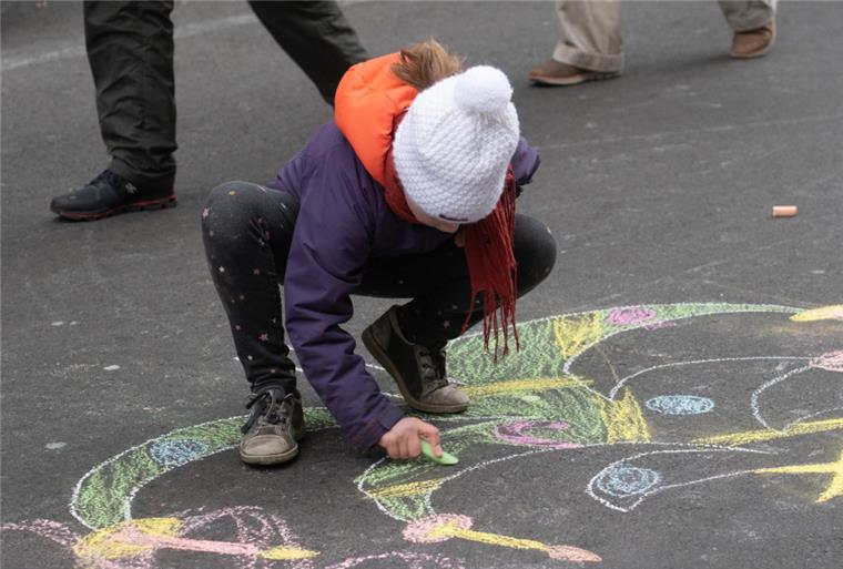 Ein Kind malt auf einer Straße. Nicht immer beschäftigen sich Kinder so selbstständig - zum Leidwesen der Eltern.