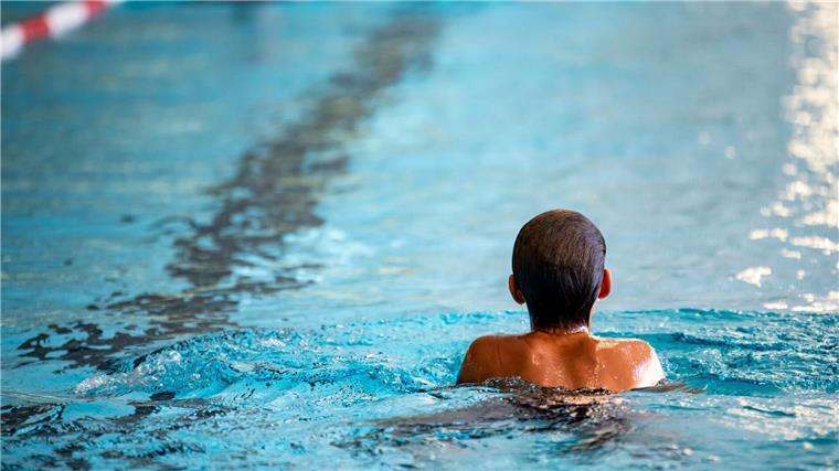 Ein Kind schwimmt in einem Schwimmbad.