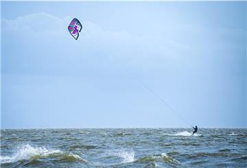 Ein Kitesurfer surft auf der Nordsee zwischen dem Festland und der Insel Juist. Für das Kitesurfen im niedersächsischen Nationalpark Wattenmeer sollen künftig neue Regeln gelten.