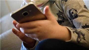 Ein kleines Mädchen schaut auf das Display eines Smartphones. Dutzende US-Bundesstaaten ziehen gegen den Facebook-Konzern Meta vor Gericht. Sie werfen dem Unternehmen vor negative Folgen für Kinder und Jugendliche zu ignorieren, um mehr Gewinn zu machen.