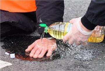Ein Klimaaktivist hat sich mit der Handfläche am Asphalt festgeklebt. Demnächst sollen auch in Bremerhaven und Bremen Gebühren für den Polizeieinsatz erhoben werden.