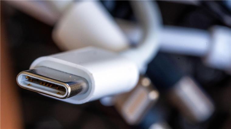 Ein Ladekabel mit USB-C-Stecker liegt neben einem Bündel unterschiedlicher Anschlusskabel.