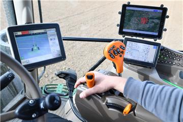 Ein Landwirt fährt einen Traktor, der mit Hilfe des Globalen Positionsbestimmungssystems (GPS) gesteuert wird. 