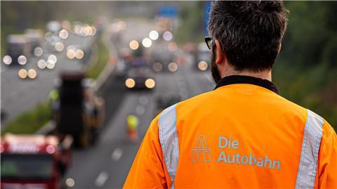 Ein Mann beobachtet Arbeiten auf einer Autobahn.