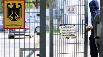 Ein Mann betritt neben einem Schild vom Bundesamt für Migration und Flüchtlinge die Landesaufnahmebehörde Niedersachsen am Standort Braunschweig.