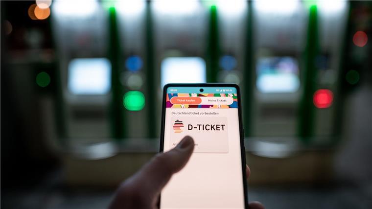 Wegen Cyberangriff: 49-Ticket verspätet beim GVH buchbar Ein Mann hält ein Mobiltelefon, auf dem das „D-Ticket“ gekauft werden kann.