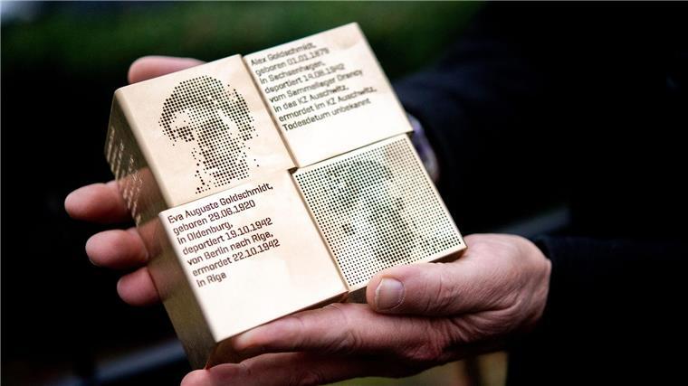 Ein Mann hält Erinnerungszeichen in den Händen.