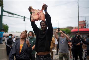 Ein Mann hält während einer Demonstration nach dem Tod von George Floyd einen Schweinekopf in Richtung Polizei.