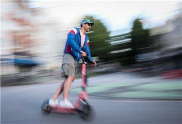 ARCHIV - 28.07.2024, Hamburg: Ein Mann ist auf einem E-Scooter in Hamburg unterwegs (Aufnahme mit langer Verschlusszeit). (zu dpa: «Wer bleibt bei Rot stehen? ADAC untersucht Verkehrsverstöße») Foto: Christian Charisius/dpa +++ dpa-Bildfunk +++