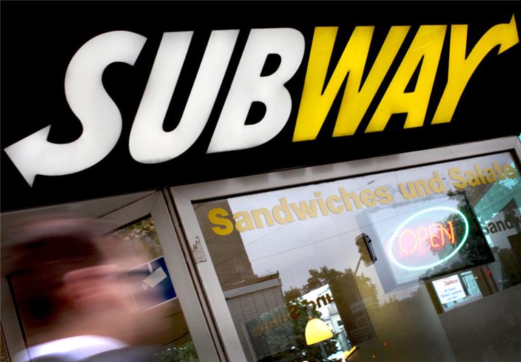 Ein Mann läuft an einer Filiale der Fastfood-Kette Subway vorbei.