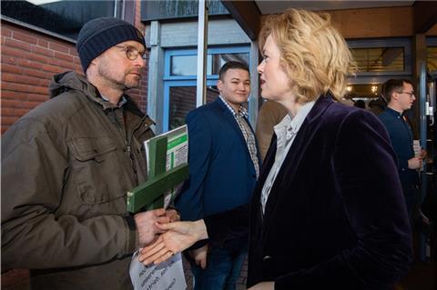 Ein Mann mit einem grünen Kreuz als Protest der Landwirte verweigert Bundesagrarministerin Julia Klöckner (CDU) vor Beginn des Junglandwirtetages der Junglandwirte Niedersachsen den Handschlag.