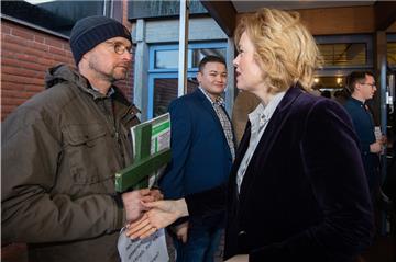 Ein Mann mit einem grünen Kreuz als Protest der Landwirte verweigert Bundesagrarministerin Julia Klöckner (CDU) vor Beginn des Junglandwirtetages der Junglandwirte Niedersachsen den Handschlag.