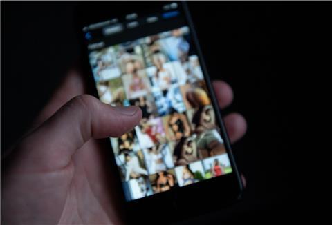 Ein Mann schaut sich auf einem Smartphone pornografische Bilder an. In Zeven soll einer anzügliche Nachrichten an Kinder und Jugendliche verschickt haben.