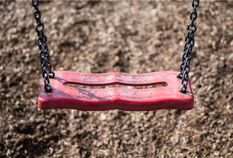 Eine Schaukel hängt auf einem Kinderspielplatz. 