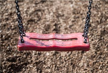 Eine Schaukel hängt auf einem Kinderspielplatz. 