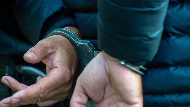 Ein Mann trägt Handschellen.