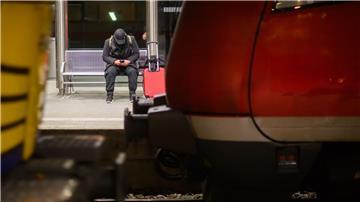 Ein Mann wartet mit Koffer an einem Gleis im Hauptbahnhof Hannover.