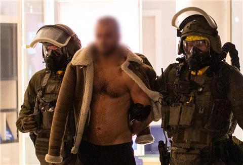 Ein Mann wird von Beamten des Spezialeinsatzkommandos (SEK) in Gewahrsam genommen.