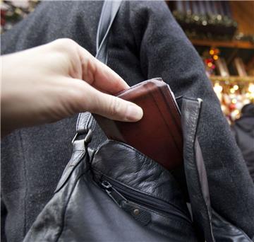 Ein Mann zieht einer Frau  die Geldbörse aus der Handtasche.  Das geschah jetzt auch in Selsingen - mit schwerwiegenden Folgen.