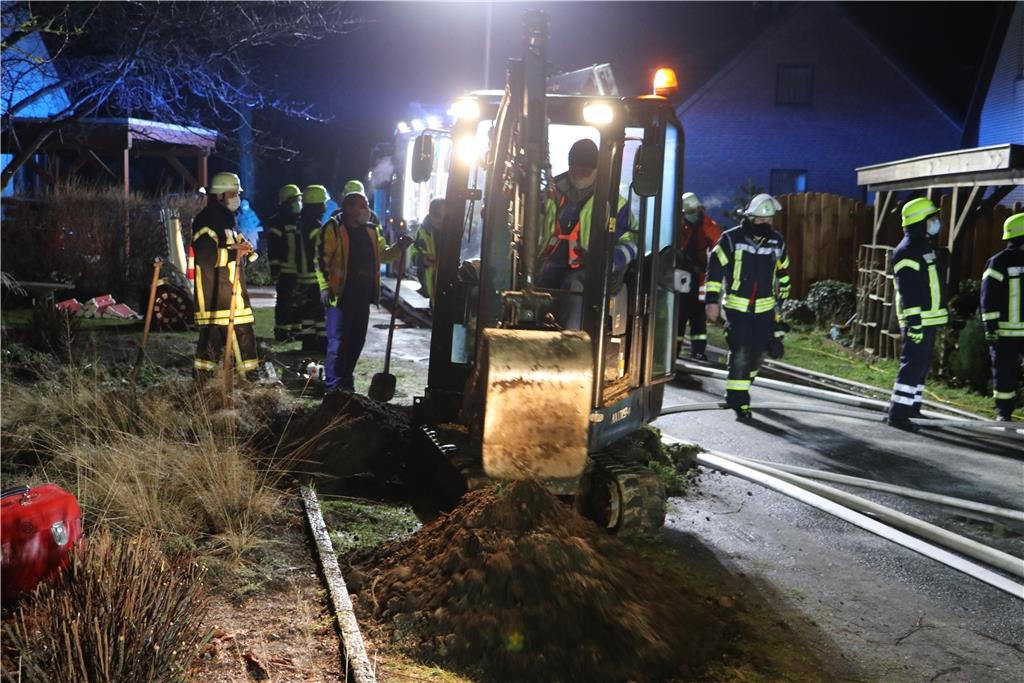 Ein Minibagger legt die Leitungen für Strom und Gas vor dem Haus frei.