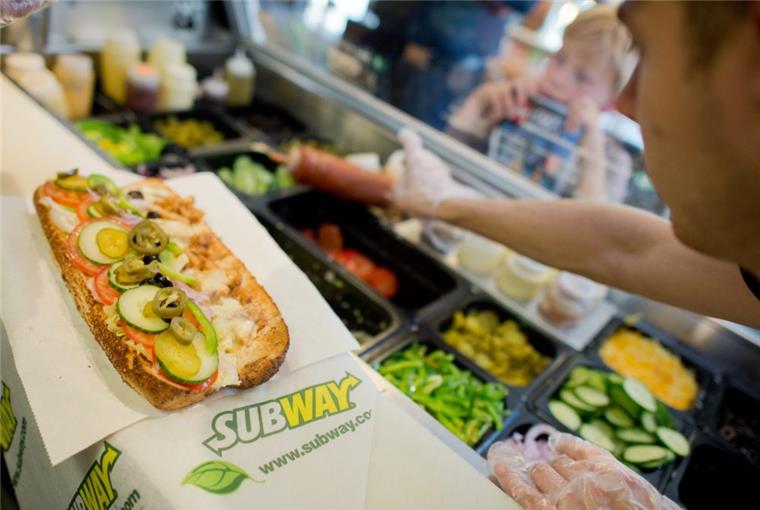 Ein Mitarbeiter belegt einen Sandwich in einer Filiale der Fast-Food-Kette Subway. 