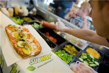 Ein Mitarbeiter belegt einen Sandwich in einer Filiale der Fast-Food-Kette Subway. 